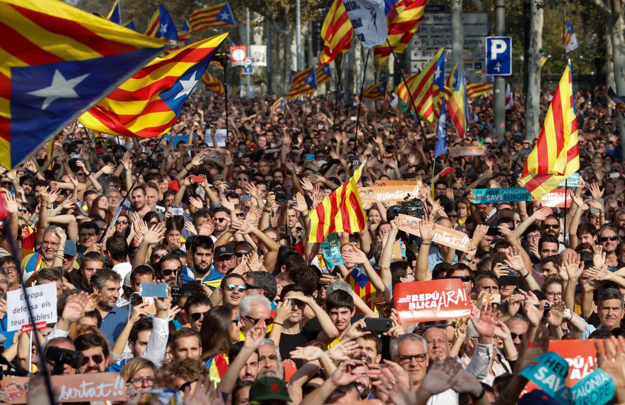 People react as they watch on giant screens a plenary session outside the Catalan regional parliament in Barcelona